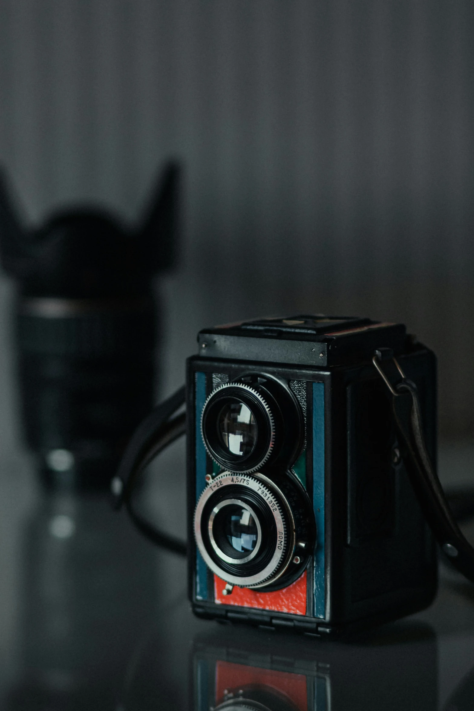 a camera on the table near another cup