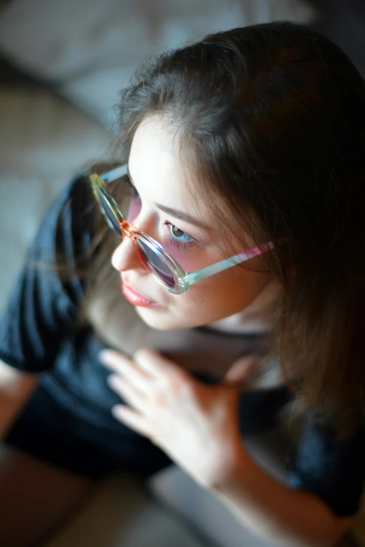 a little girl wearing glasses looking over her shoulder