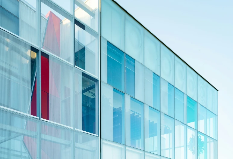 a large building has windows that have red and blue shades