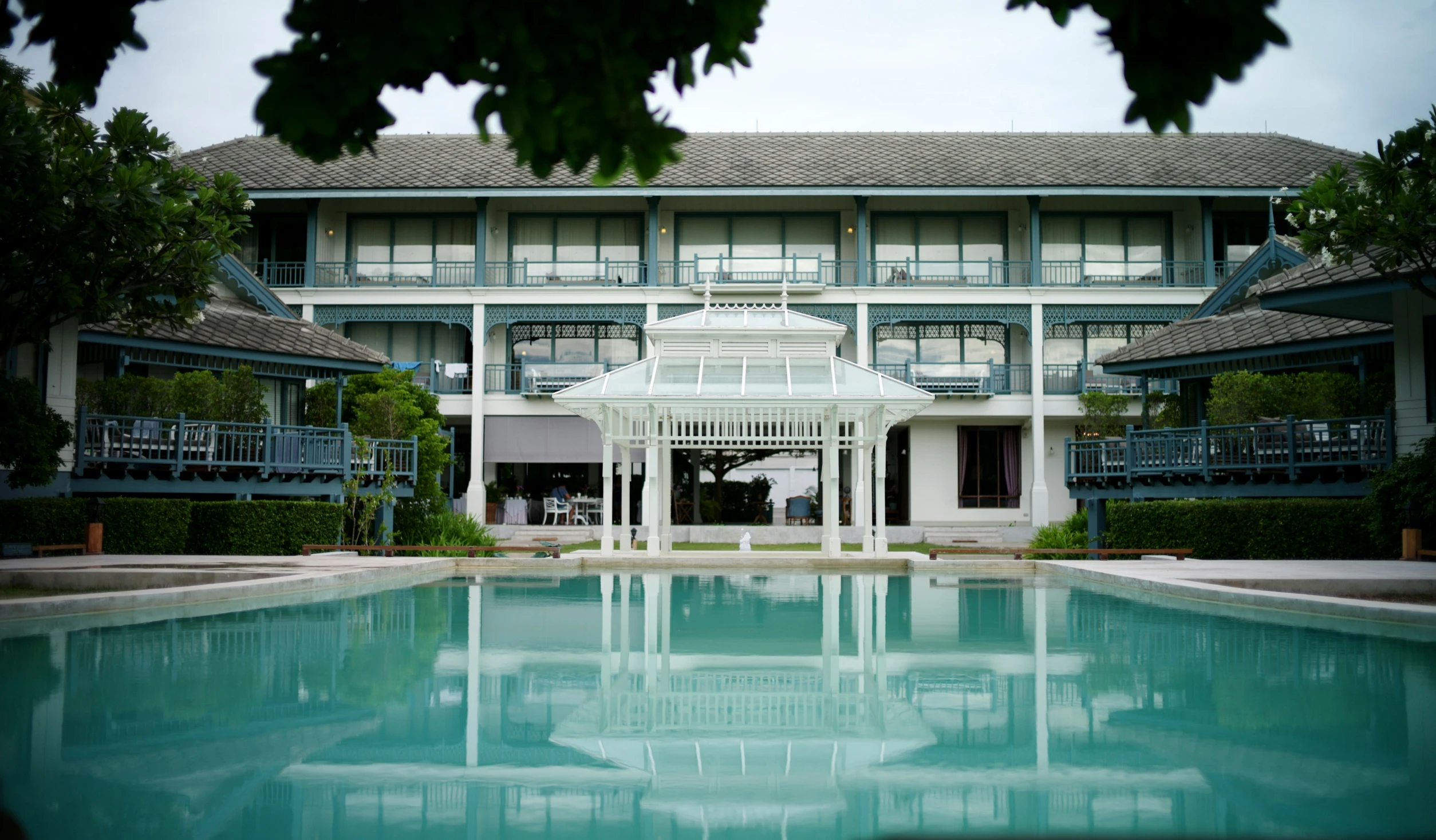 large white building with a pool in front of it