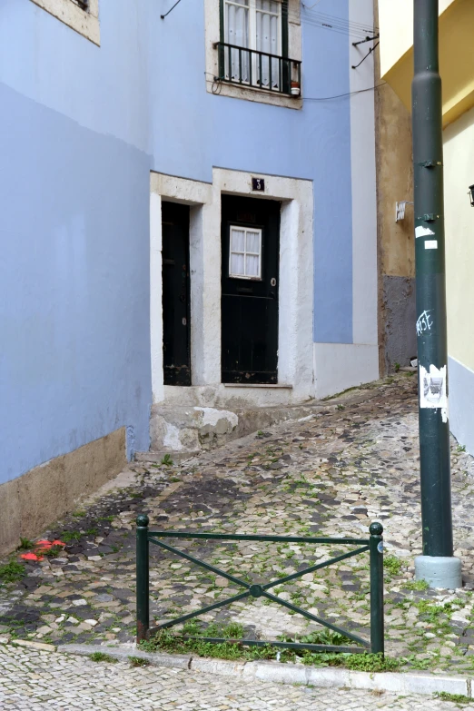 a sidewalk with a gate in front of an apartment building