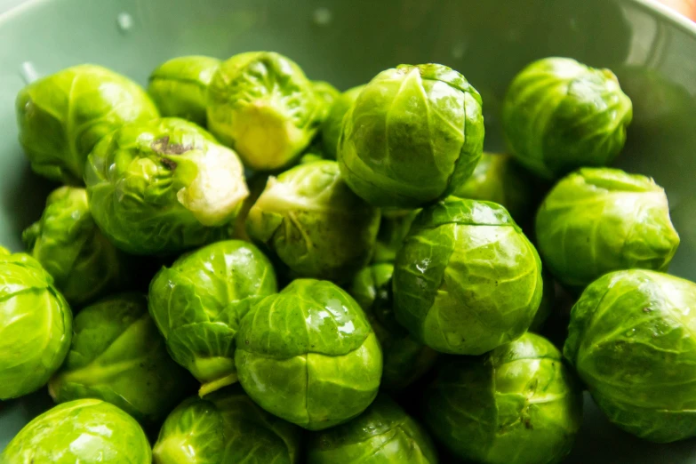 brussel sprouts in a bowl with orange background