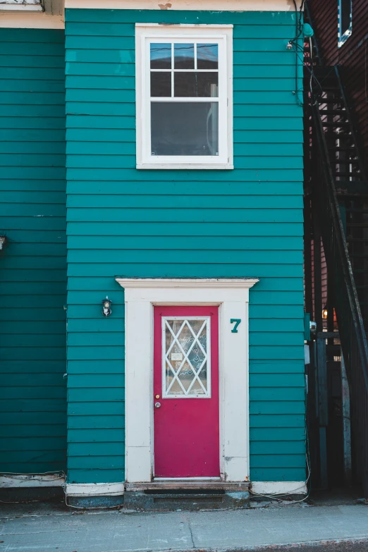 a blue building with a red door and window