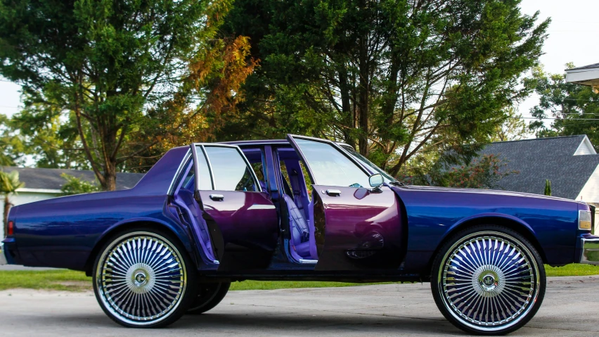 a fancy blue and purple car is shown in the driveway