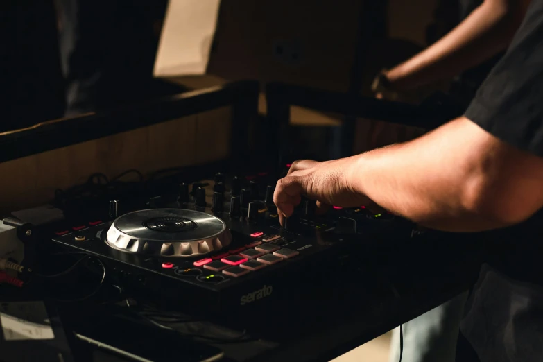 the person is preparing to use a dj controller