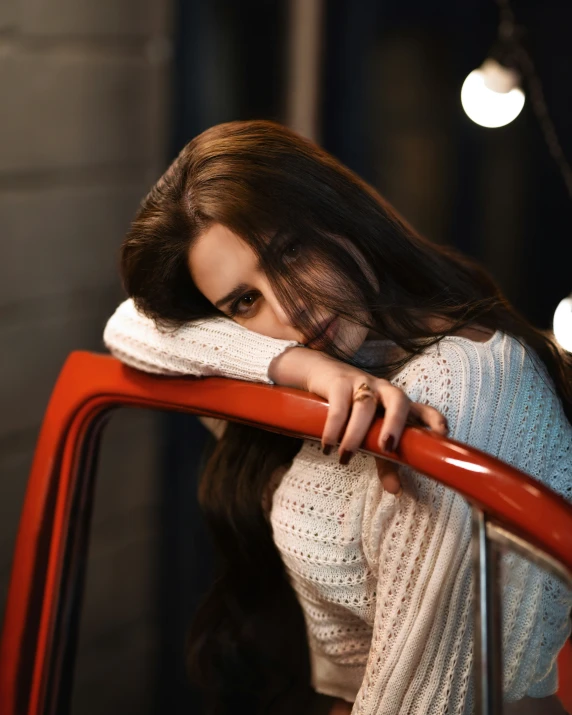 a woman leaning against a red metal rail