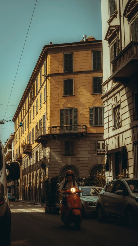 a man riding on the back of a motorcycle down a street