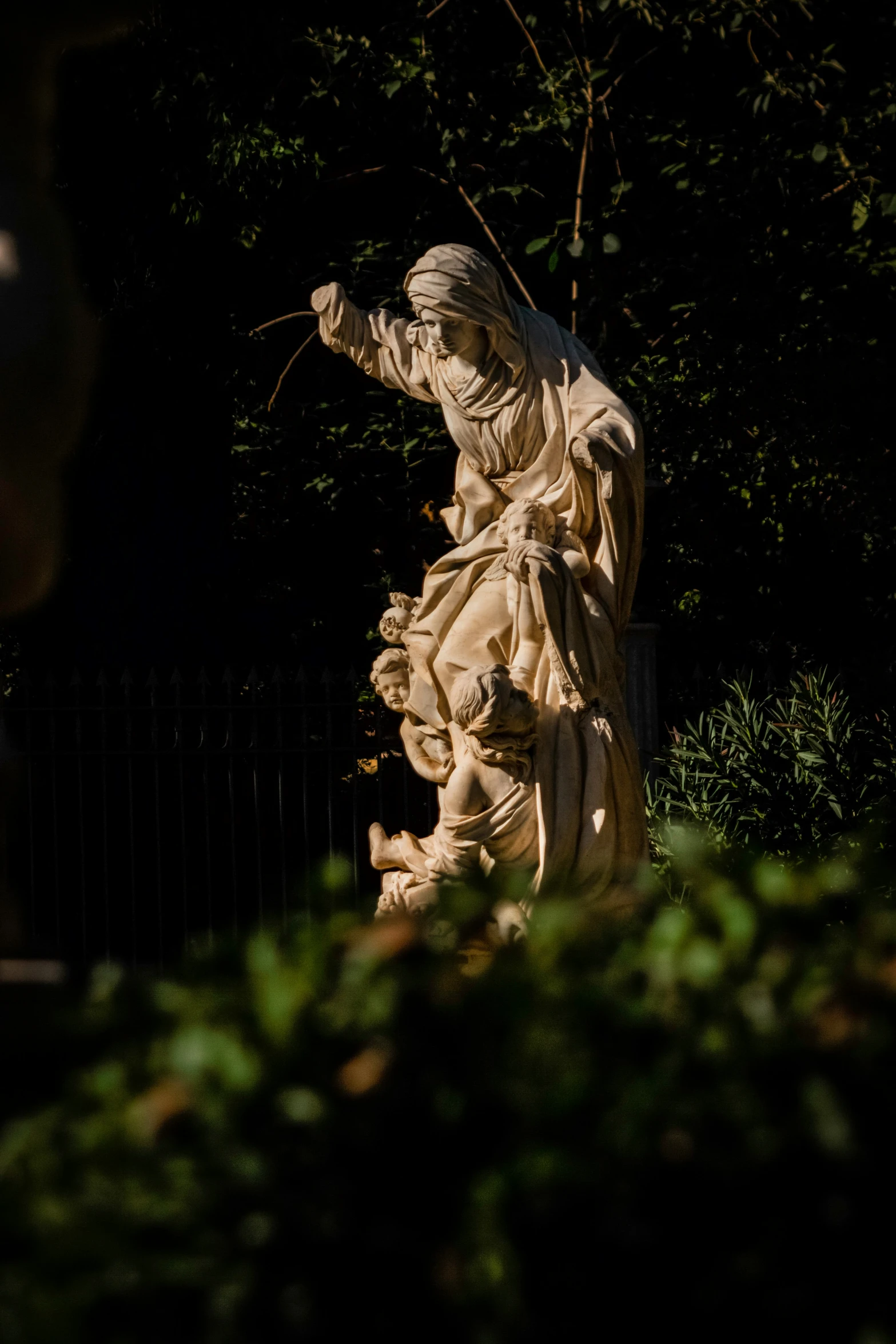 a statue of an angel is next to the fence