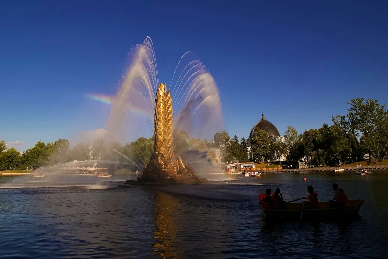 a small boat driving by a fountain and a man