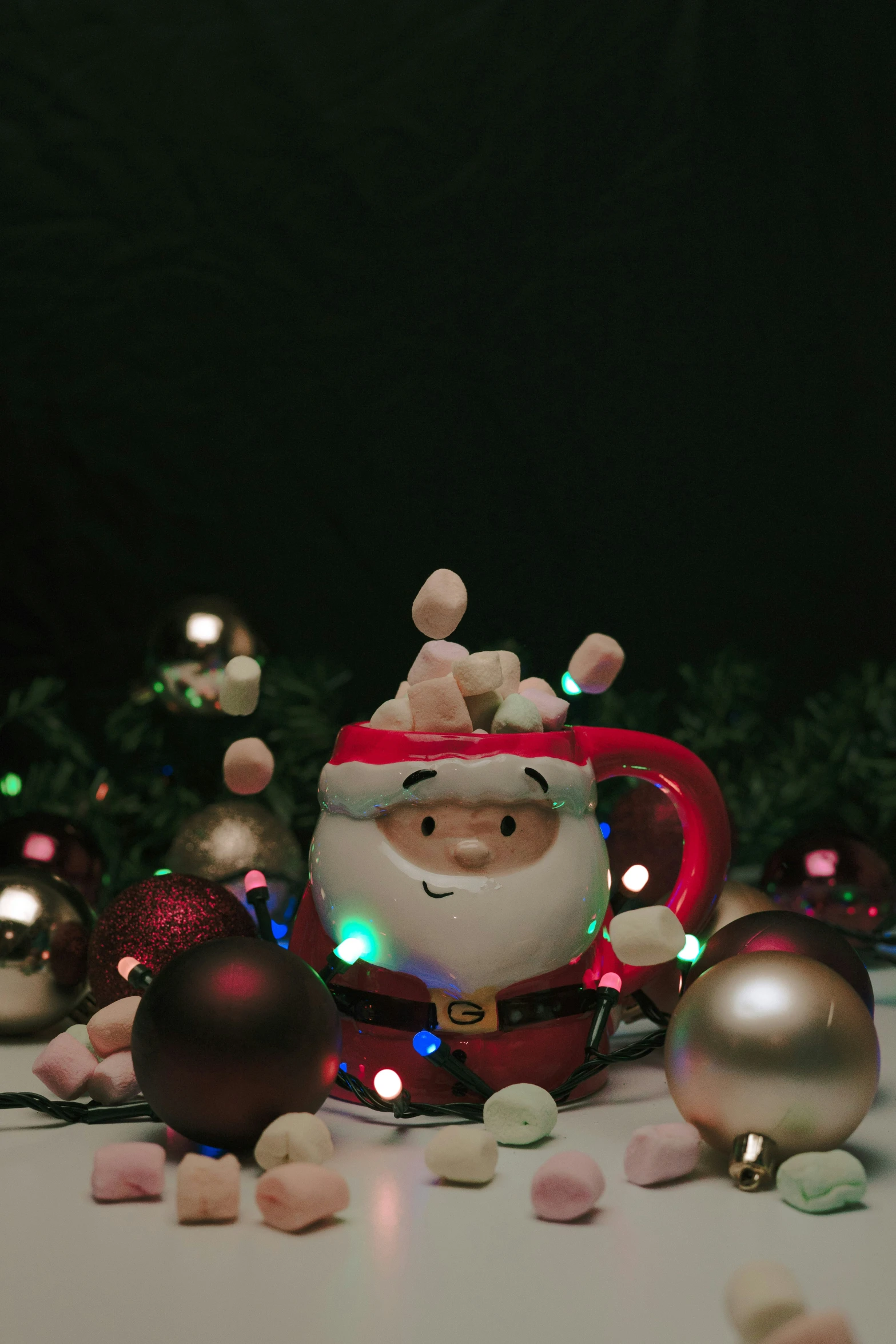 a santa tea pot in front of christmas decorations