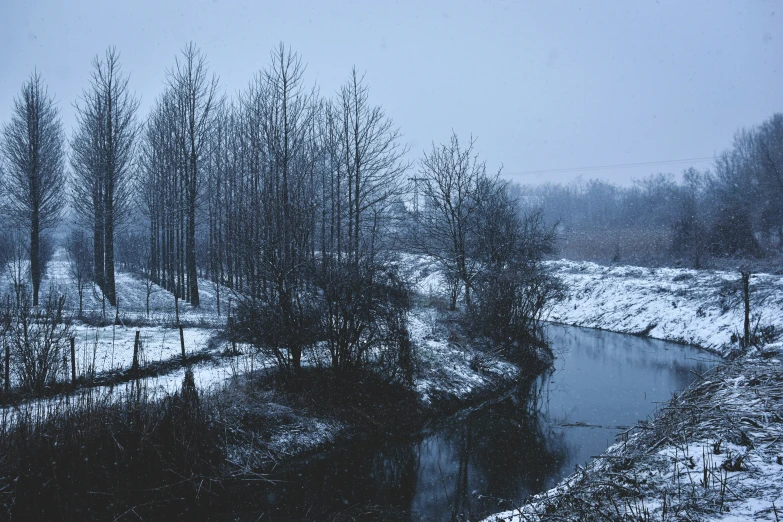 the view from a bridge looks down at a snowy river