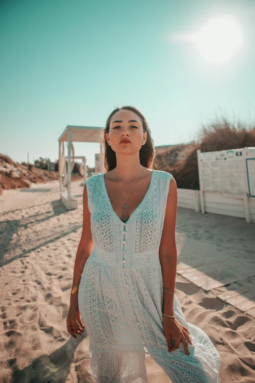 a woman standing on the beach, looking up