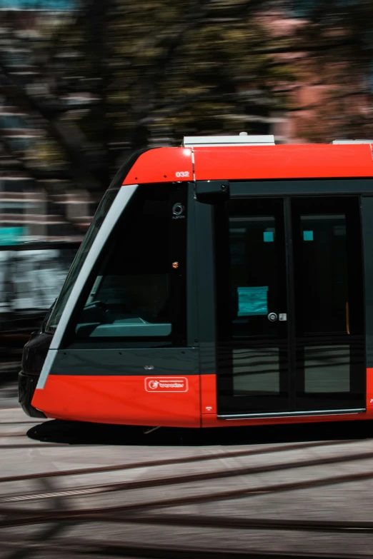 a small train with an open door passing down the street