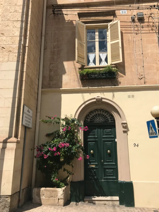 a green door and window on an old building