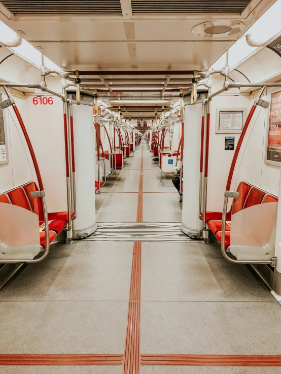 empty white and red trains with seats arranged at different levels