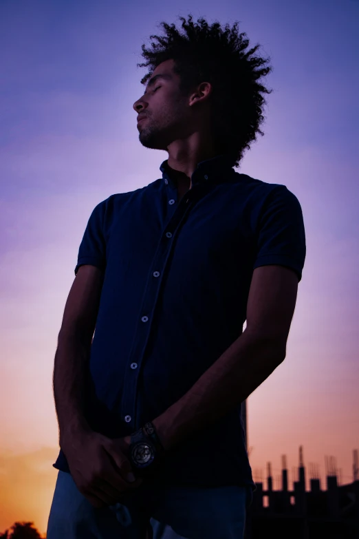 a man is staring at the horizon in front of buildings