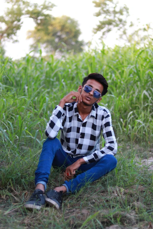 a man sits on the ground in a field