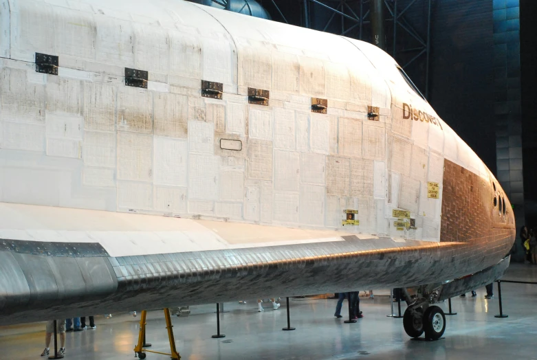 the space shuttle sits on display inside a large building