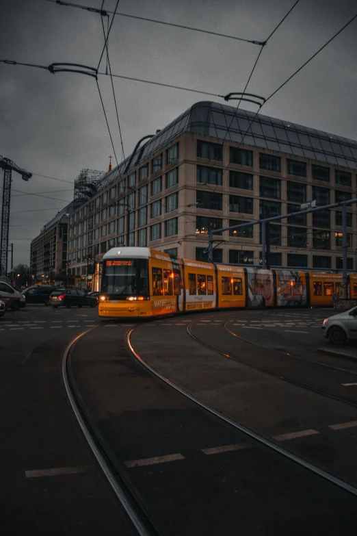 a yellow transit bus driving down a street next to a building