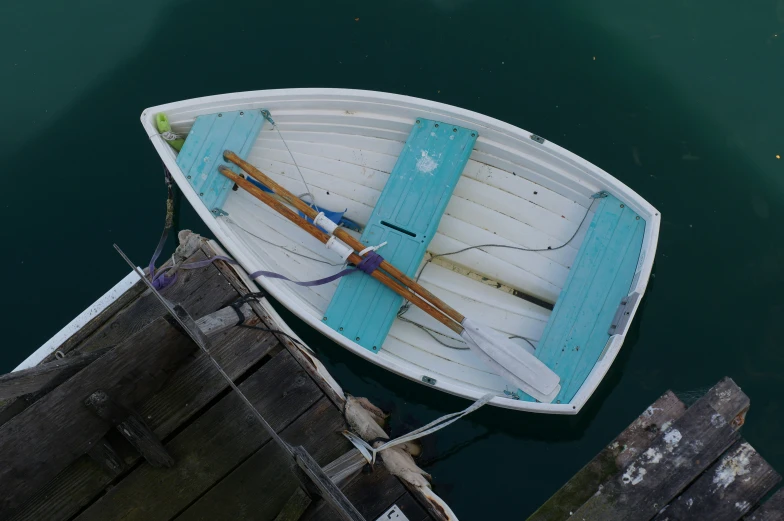 a white and blue boat with rope on water