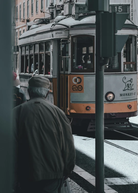 a trolly car on a train track near a pedestrian crossing