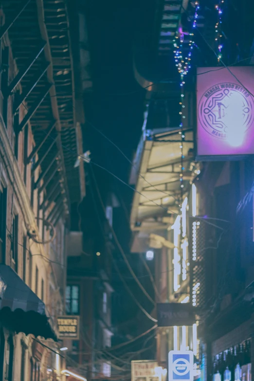 several large signs suspended above a narrow city street