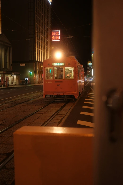 a tram is coming down the tracks at night