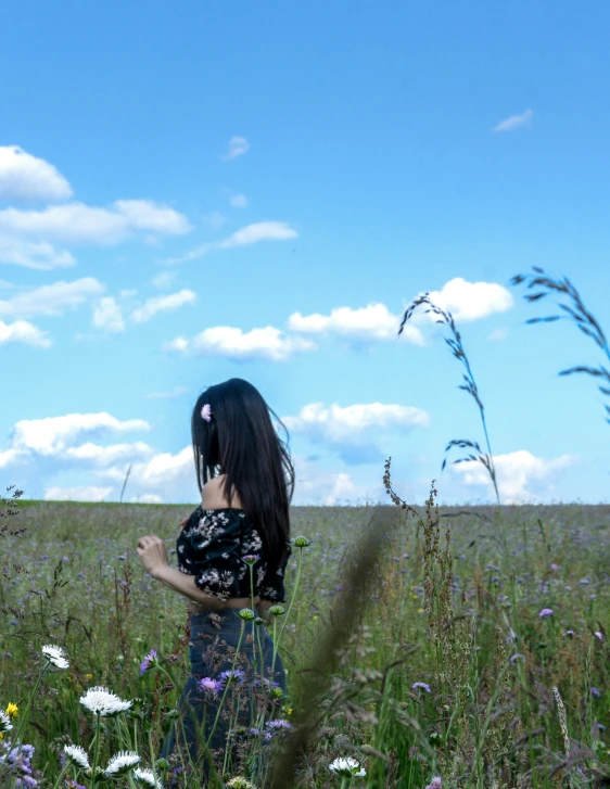 girl in a field holding a flower