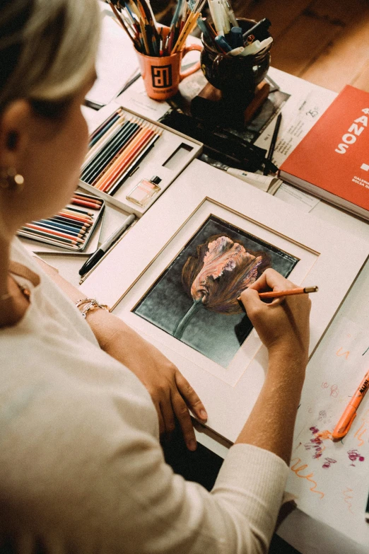 a woman working with artwork at a desk