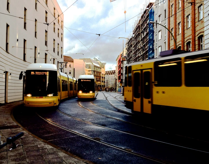 two yellow train engines parked near a bunch of buildings