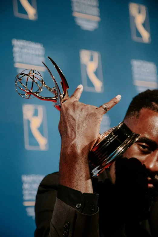 the man holds his trophy up in victory