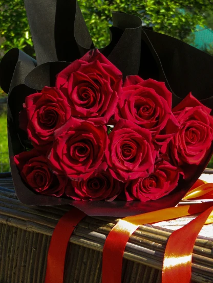 a bouquet of roses sitting on top of a wooden bench
