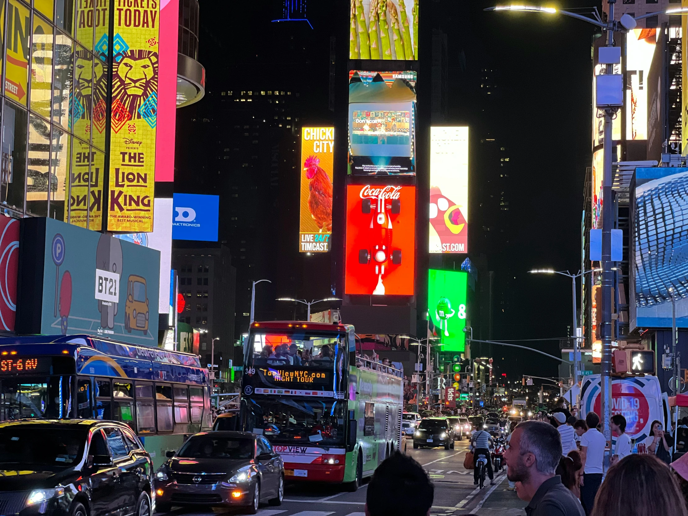 crowded city street at night with billboards lit up