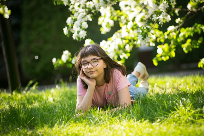 a girl laying on the ground wearing glasses