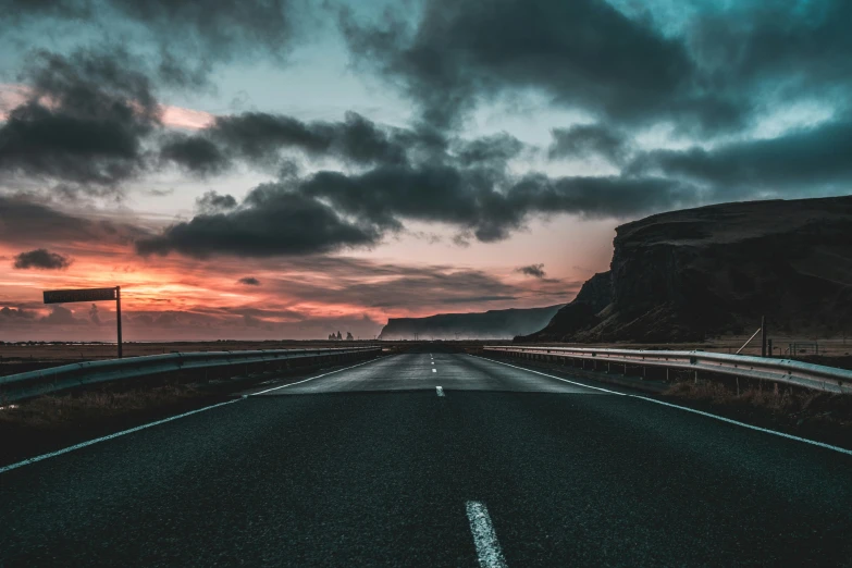 the sun setting over a lonely and empty road