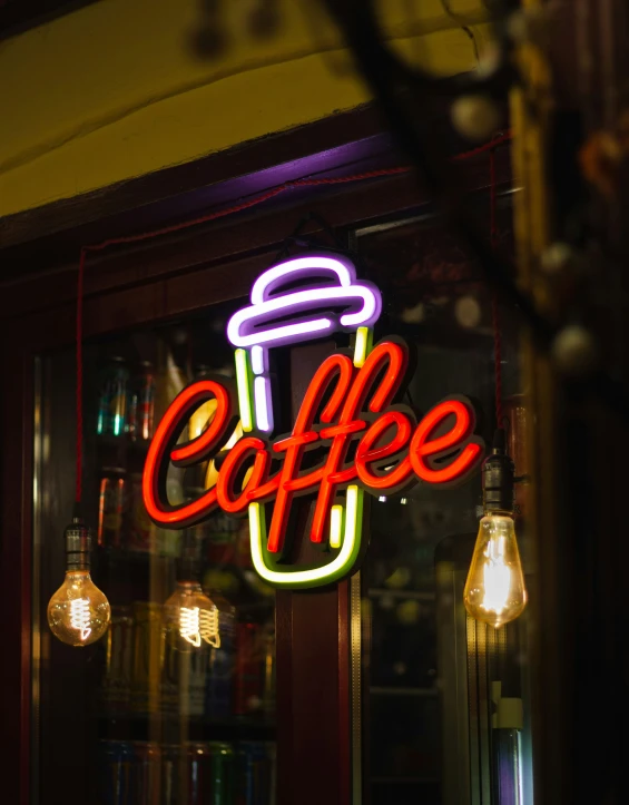 a neon cafe sign with some lights and a cake
