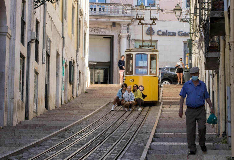 a group of people standing and sitting on the side of a street