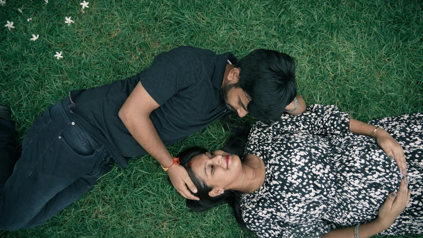 a woman and man laying on top of each other