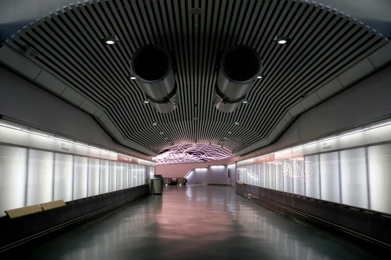 inside of a building with some benches and ceiling lights