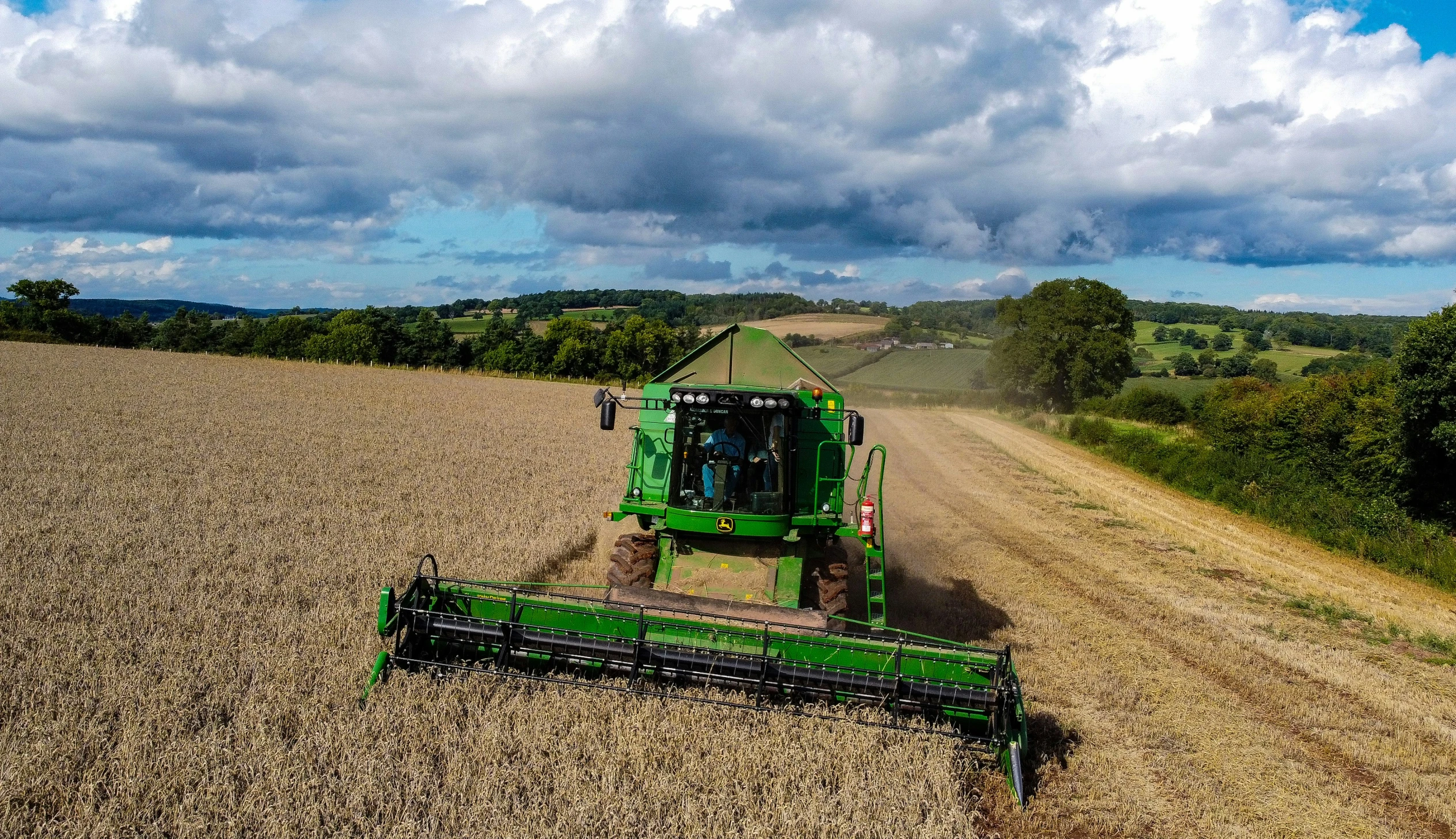 tractor and corn stalk in field with clouds