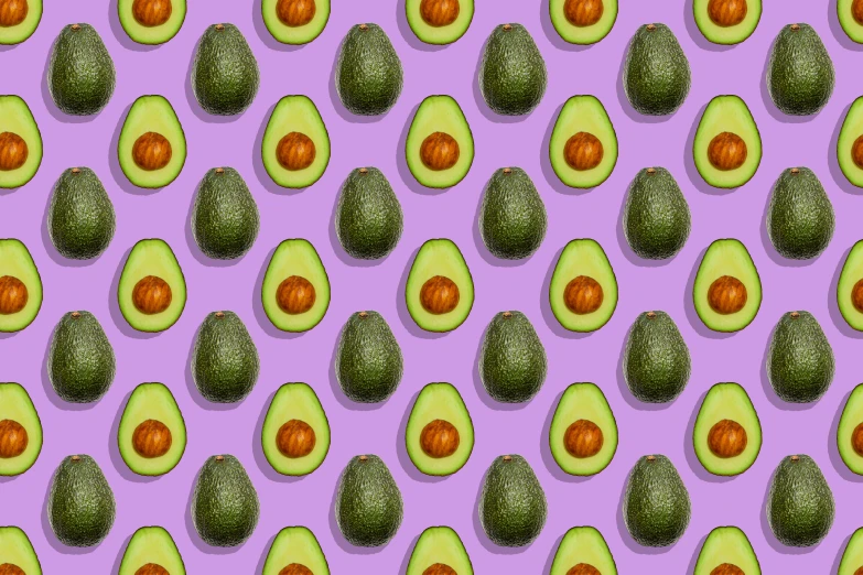 an avocado with oranges and leaves on a pink and purple background