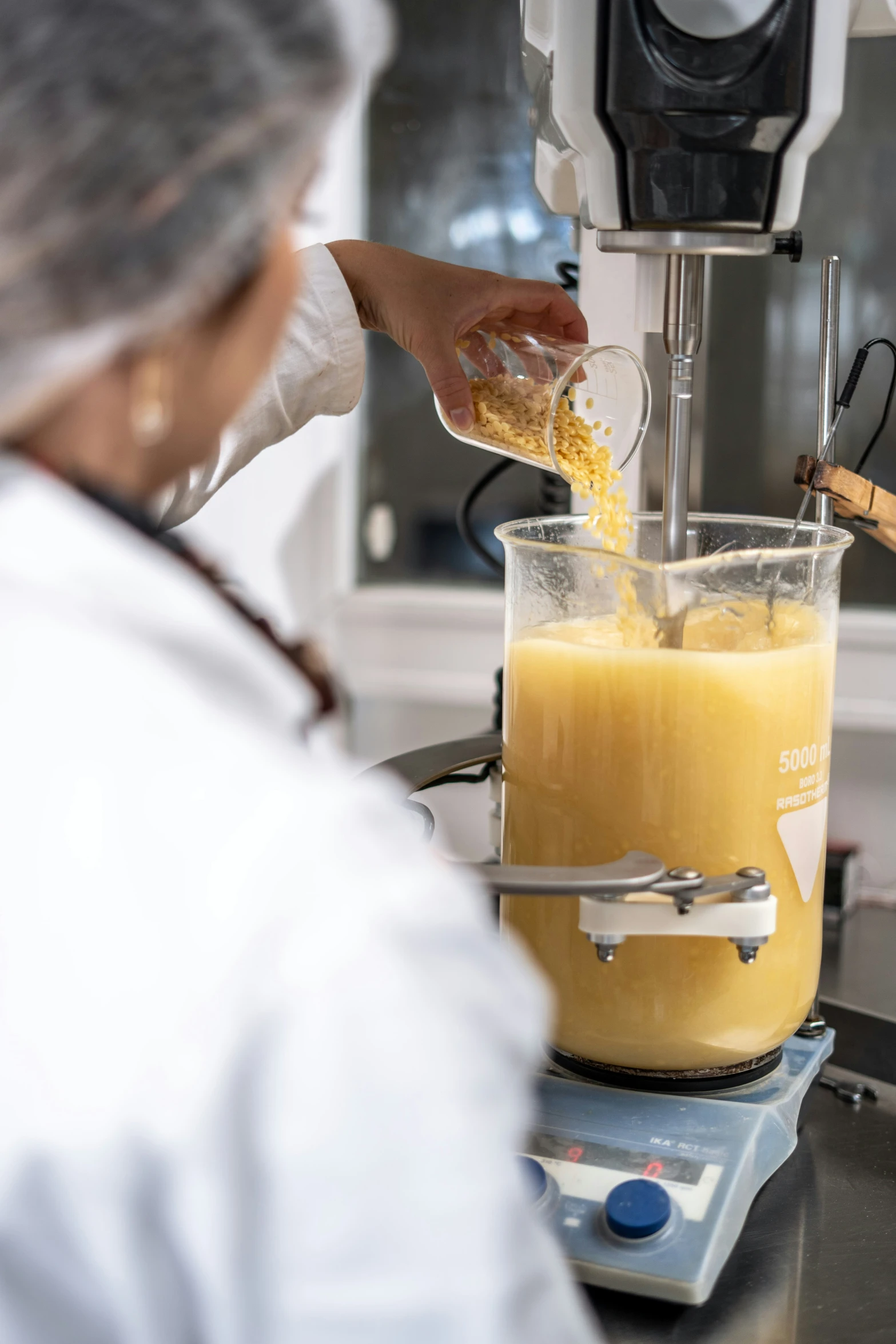 a person pours orange juice in a blender