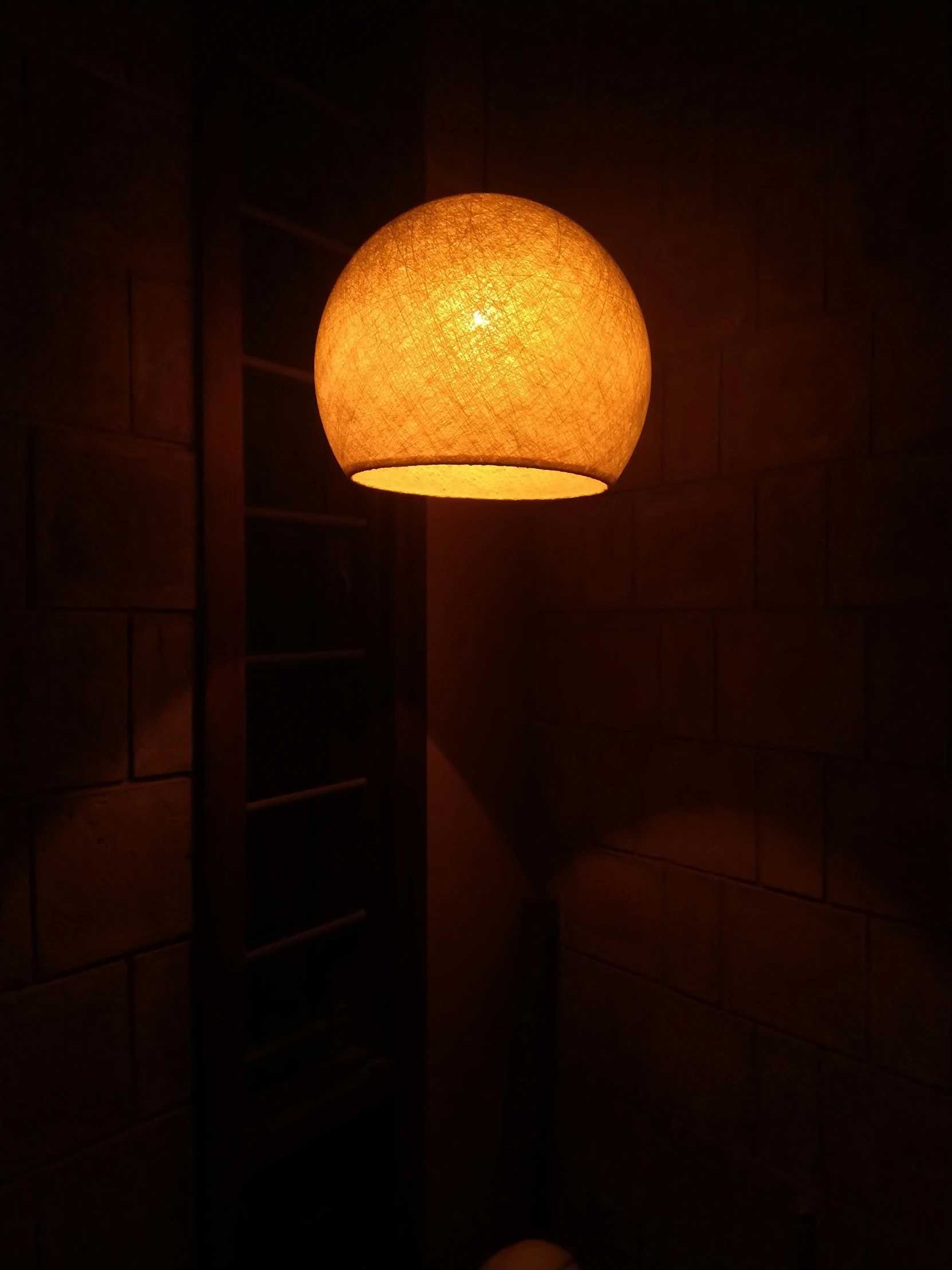 a floor lamp sitting on top of a brick floor