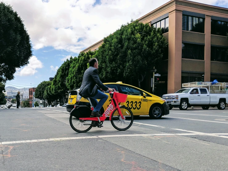 a man riding a red bike in the street