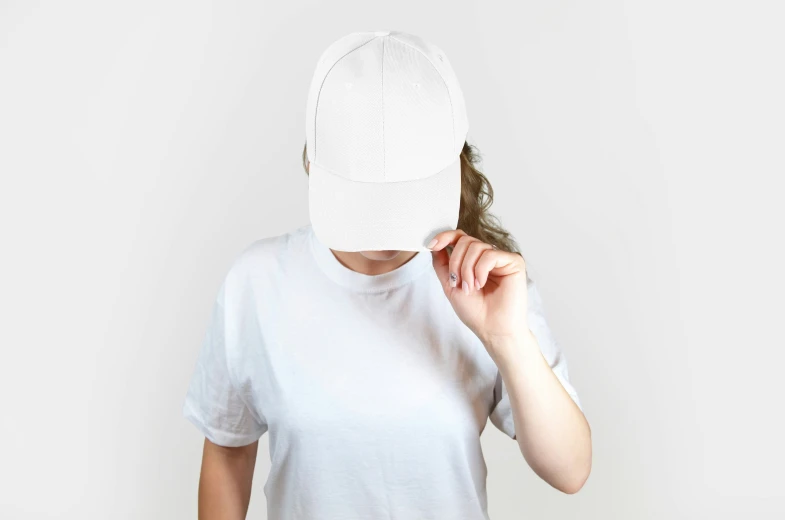 a woman is hiding behind a cap