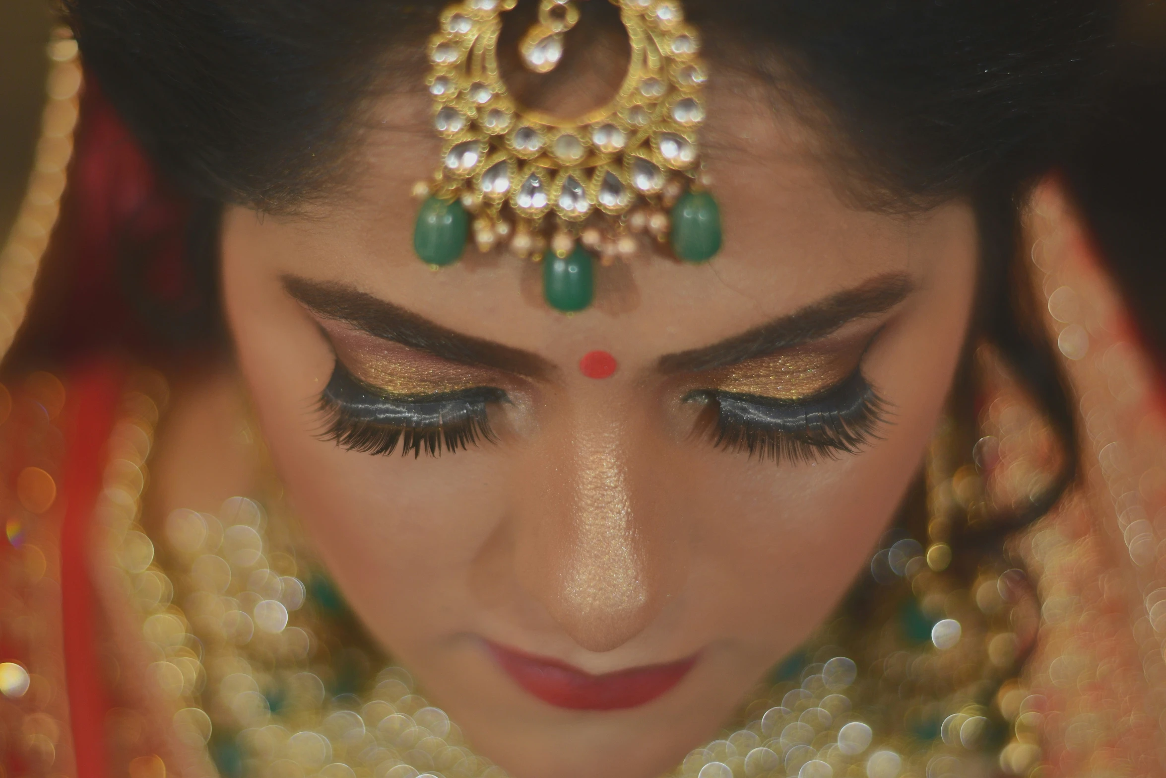 a woman in indian dress is putting on her eye make up