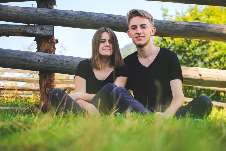 a couple of people that are sitting in the grass