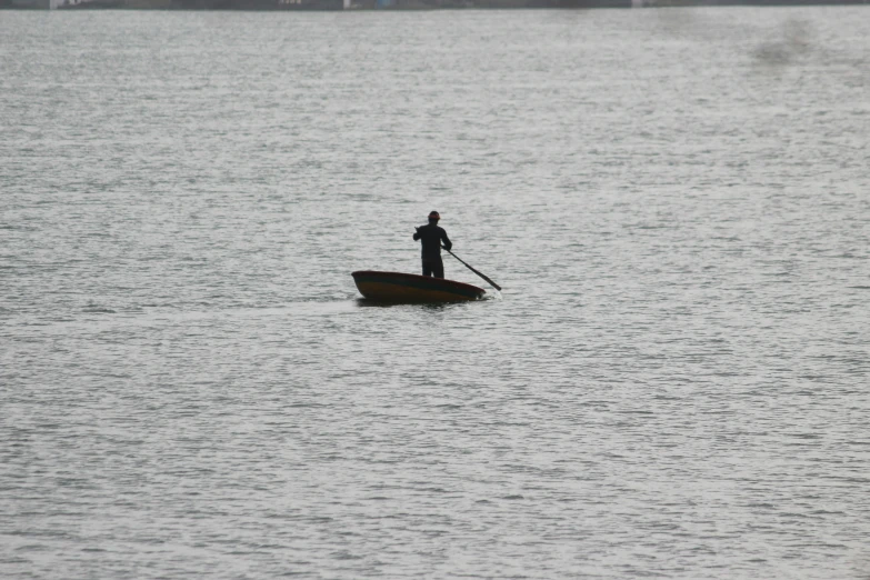 a man is rowing his boat in the water