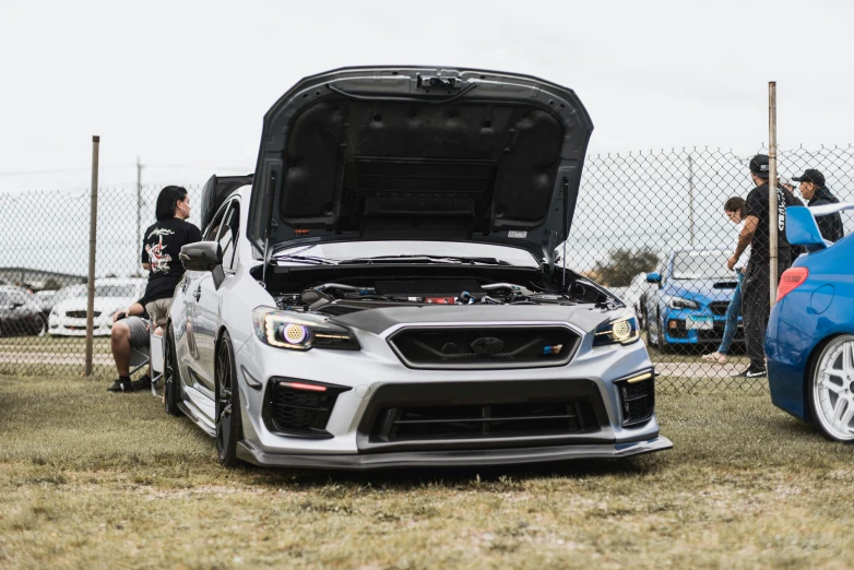 the two cars have hood open at the event