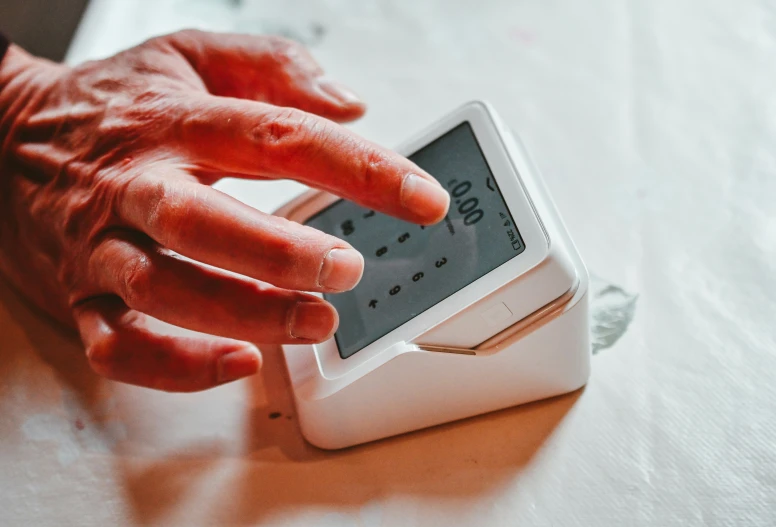 a persons hand on top of a small device